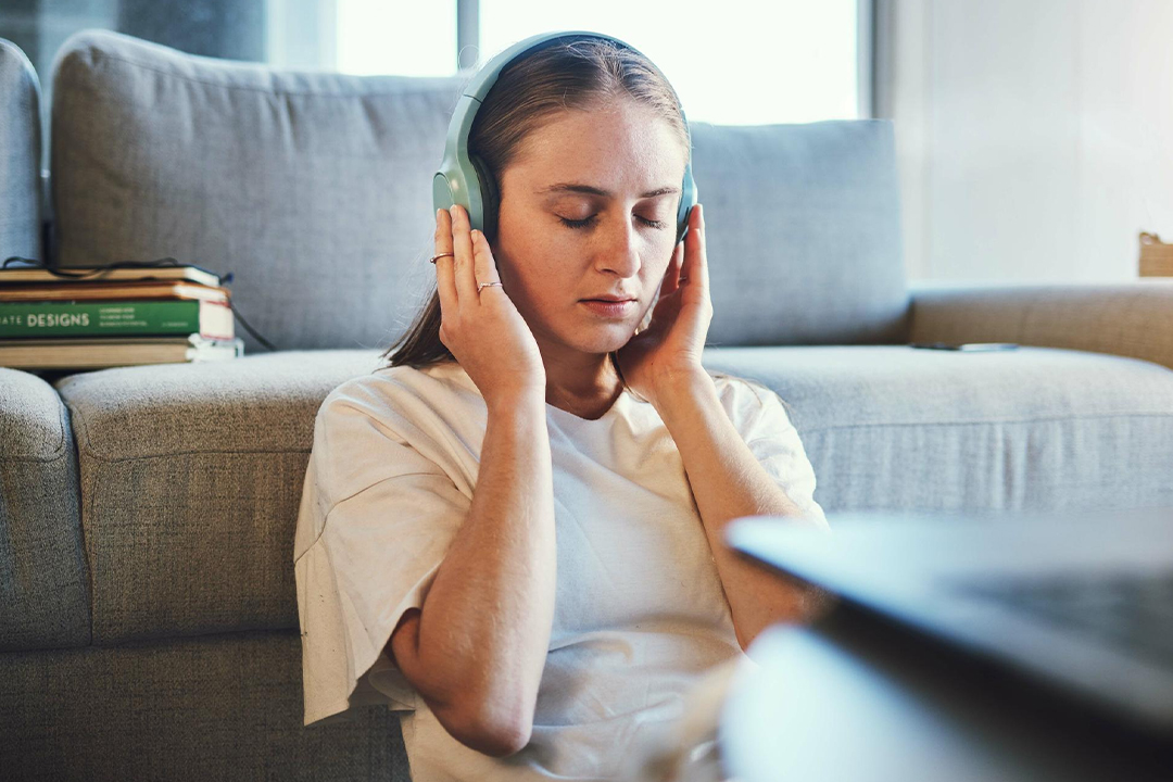 Young beautiful woman wears casual shirt working at night, has terrible headache, tries to concentrate and continue preparing for classes, isolated on dark background. Tiredness and education concept.