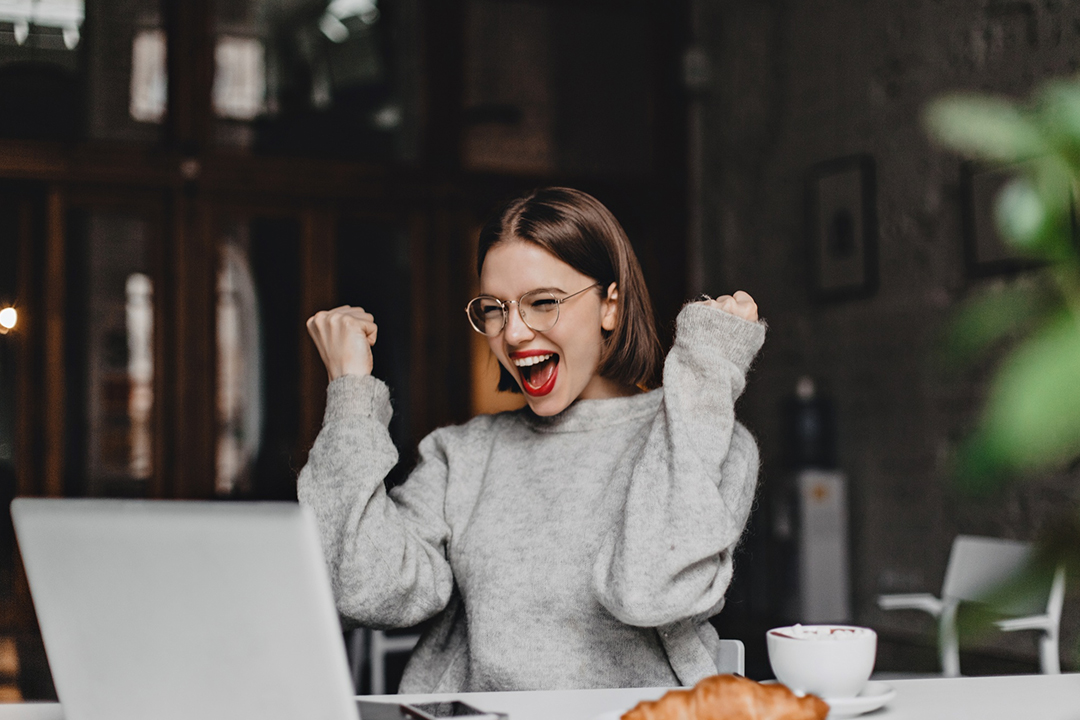 Young beautiful woman wears casual shirt working at night, has terrible headache, tries to concentrate and continue preparing for classes, isolated on dark background. Tiredness and education concept.